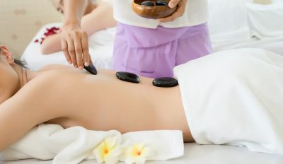 Young beautiful woman getting hot stone spa treatment.